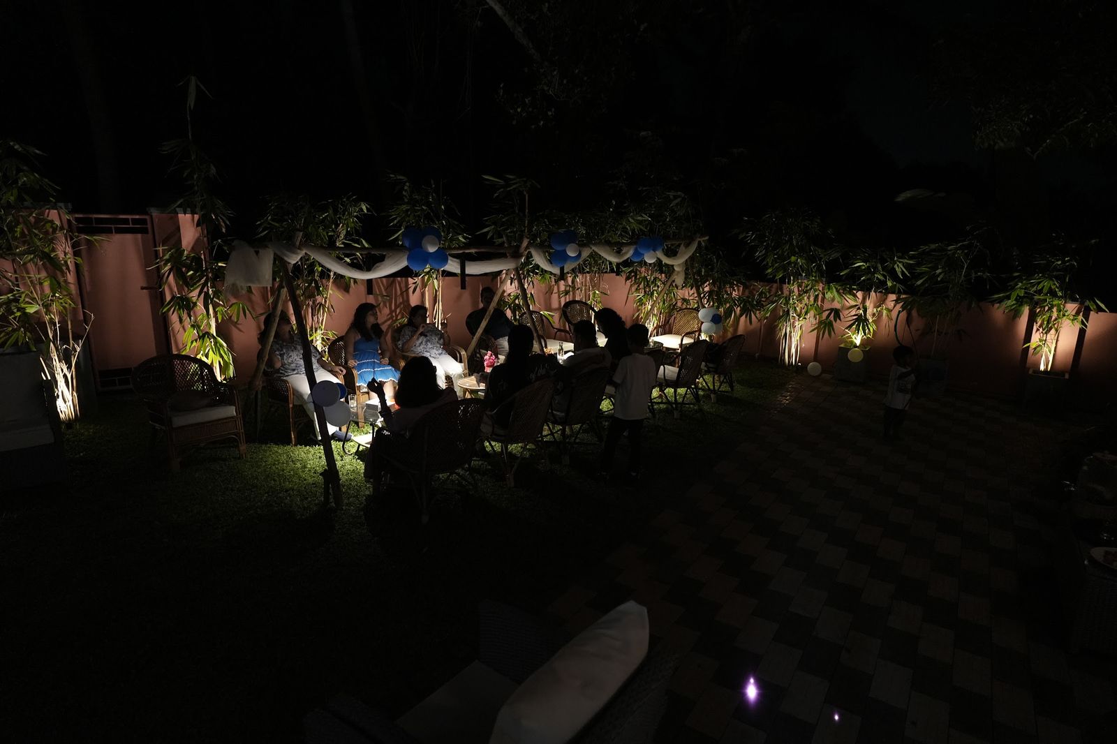 Guests under string lights in the garden at night