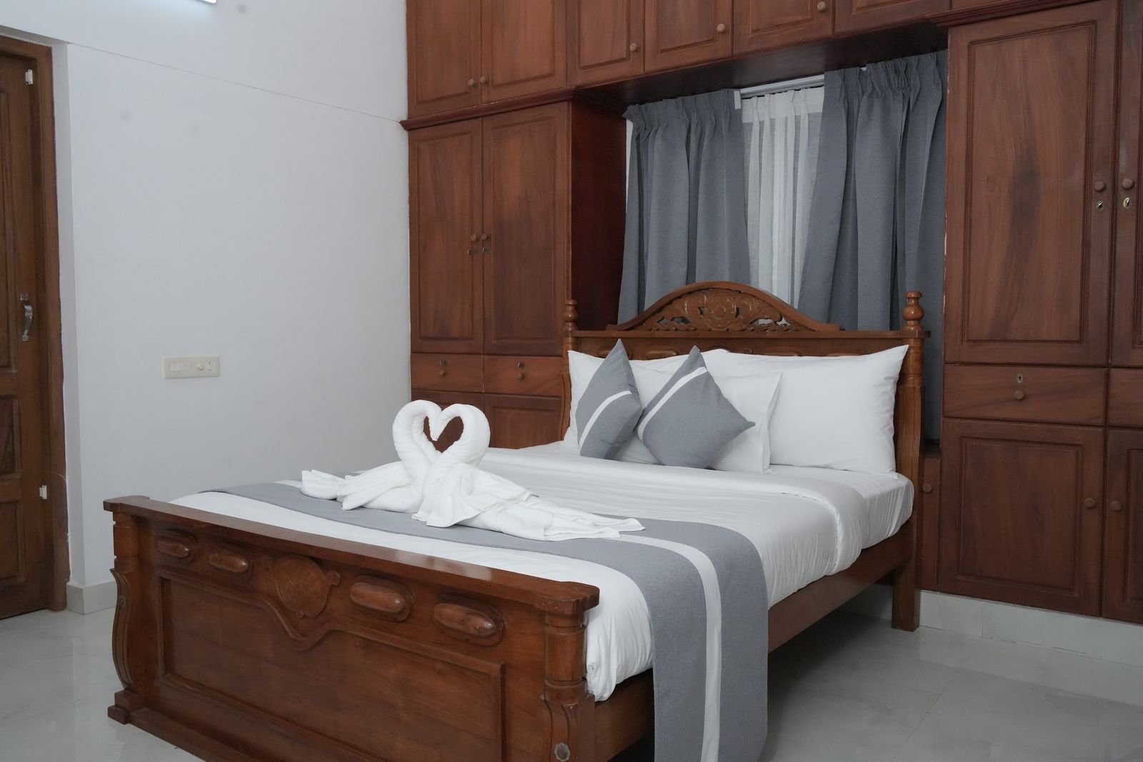 La Suite Casa, a carved wooden bed between full height wardrobes