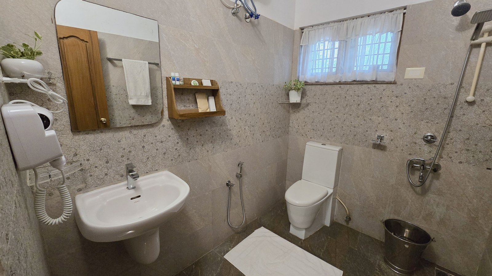 The bathroom of Casa Verde, stone tiled with a window over the garden