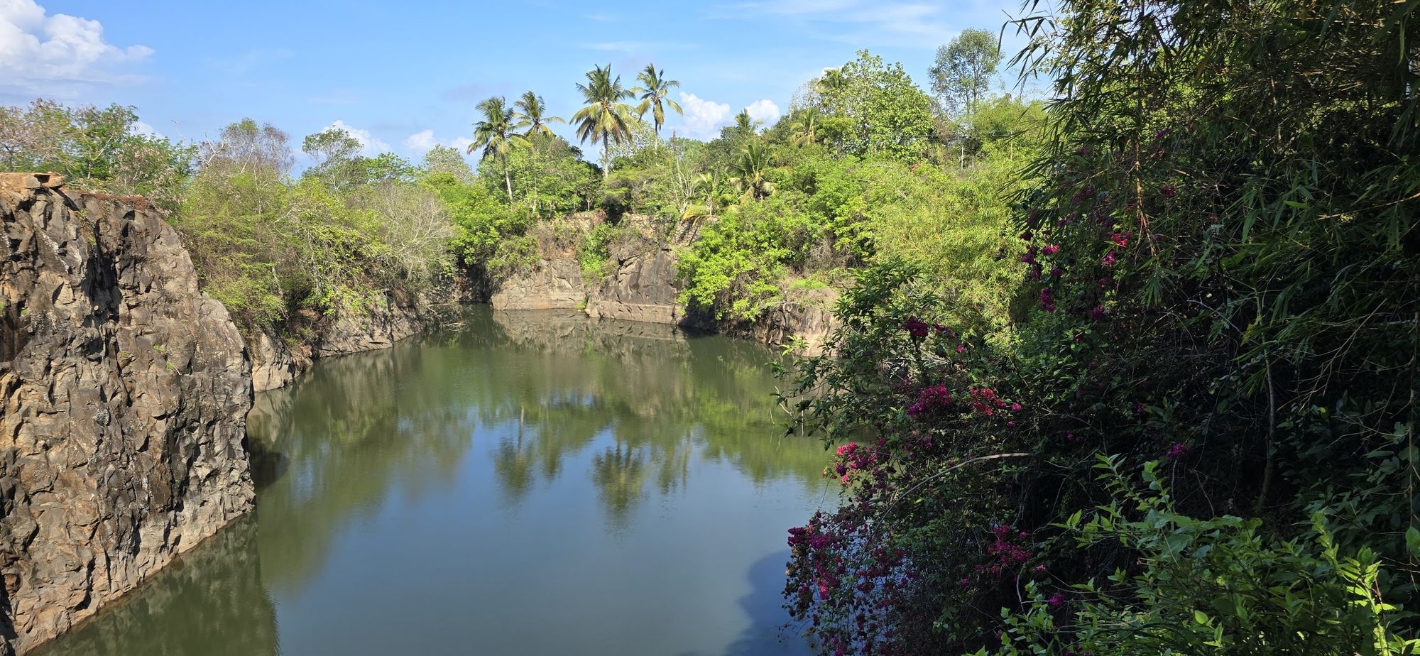 The private freshwater lagoon below the houses, rock walls and palms reflected in still water