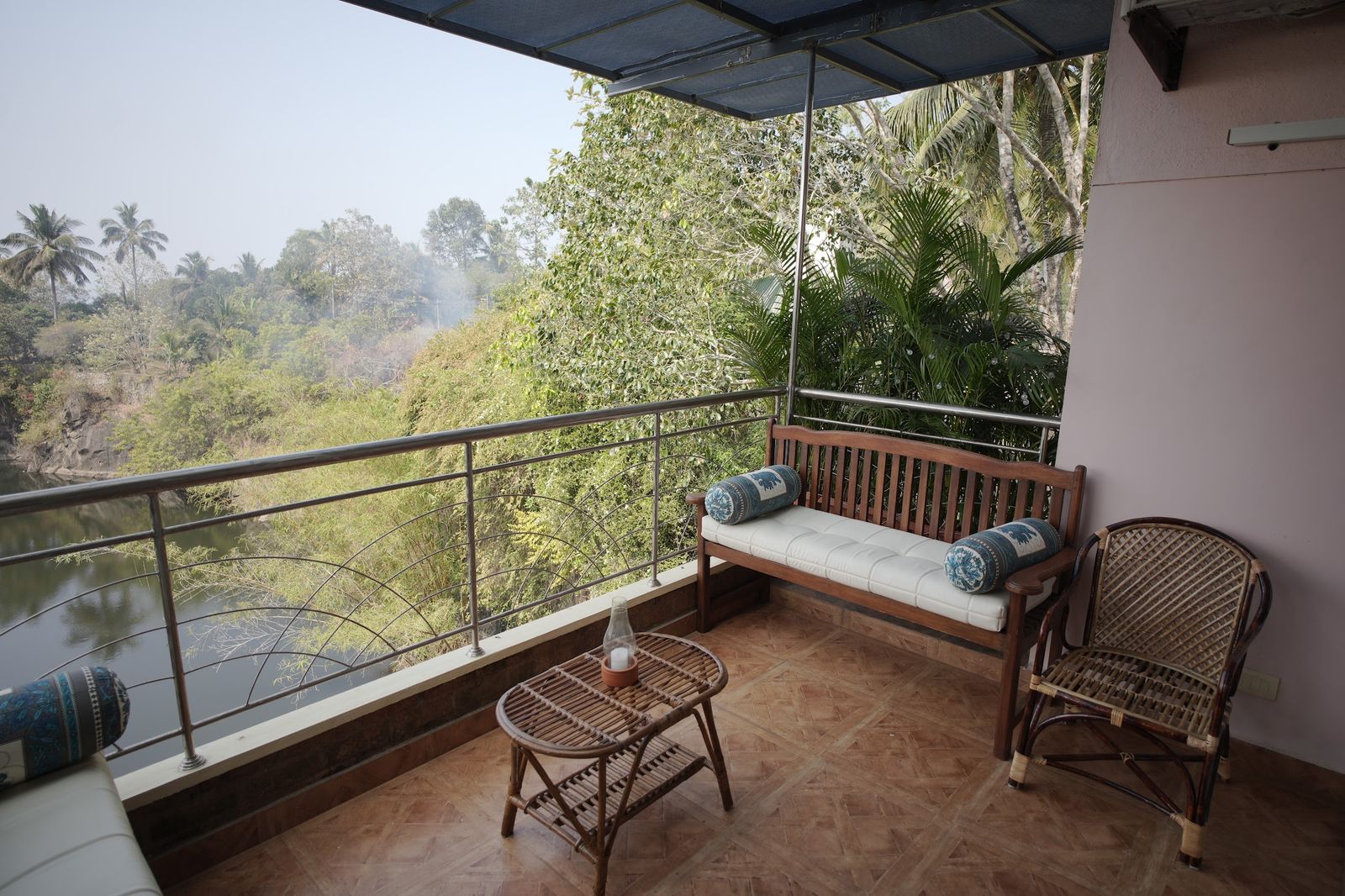 The Sanctuary balcony at The Cove, a daybed above the water and the trees